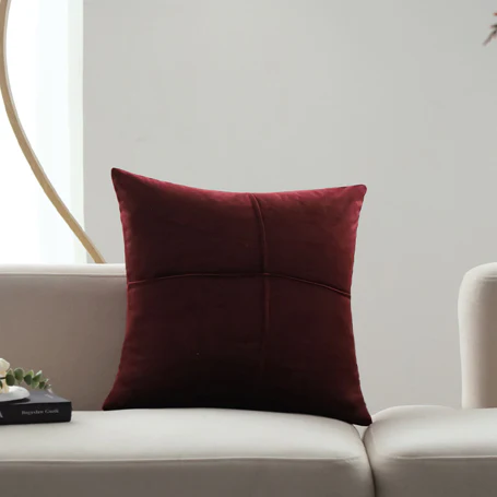 Housse de coussin velours bordeaux RUBY sur un canapé blanc - Coussin décoratif bordeaux élégant et doux.