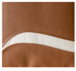 Housse de coussin design "Mocha" - Coussin marron chocolat avec motif ondulé blanc sur canapé beige.