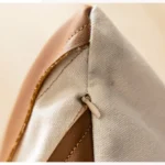 Housse de coussin design "Mocha" - Coussin marron chocolat avec motif ondulé blanc sur canapé beige.