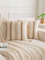 Deux housses de coussin bohèmes Twisted beiges sur un canapé blanc avec plaid