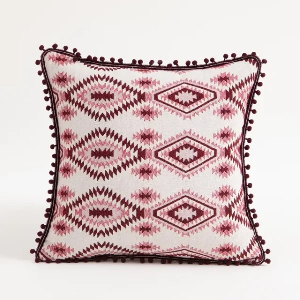 Coussin motifs géométriques Harmony rose et blanc avec pompons