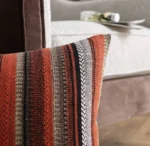 Housse de coussin rayée Rosewood sur un accoudoir de canapé beige