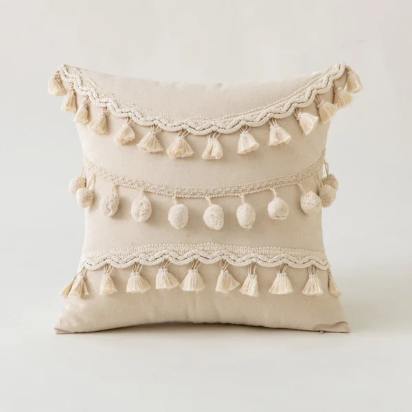 Housse de coussin bohème beige avec pompons et franges, coussin décoratif ethnique en coton, style désert.