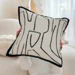 Coussin design noir et blanc avec motifs géométriques pour décoration intérieure moderne.